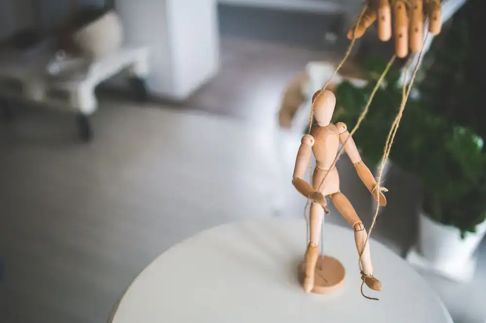 Instructor demonstrating string tension on a classic marionette