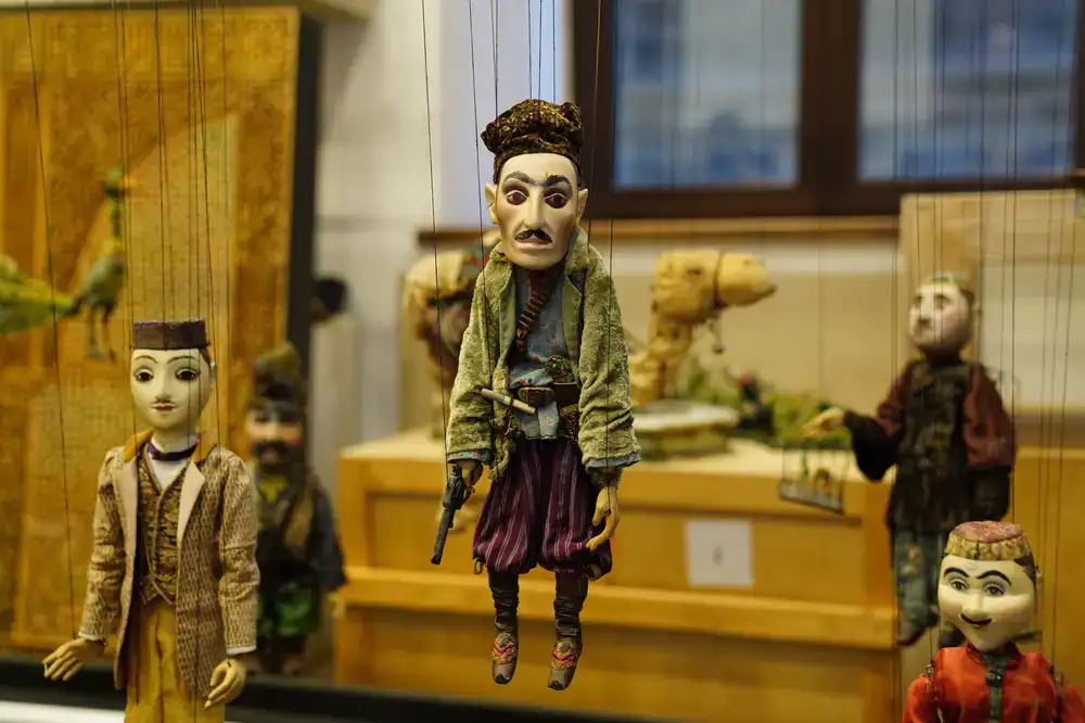 Puppeteer preparing marionettes behind the velvet curtains